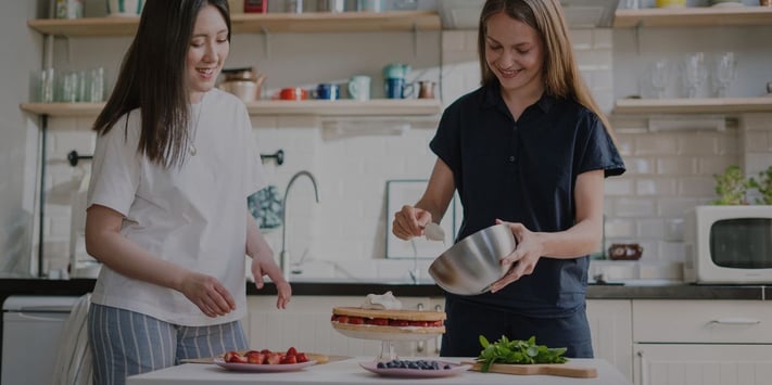 two female friends baking a cake