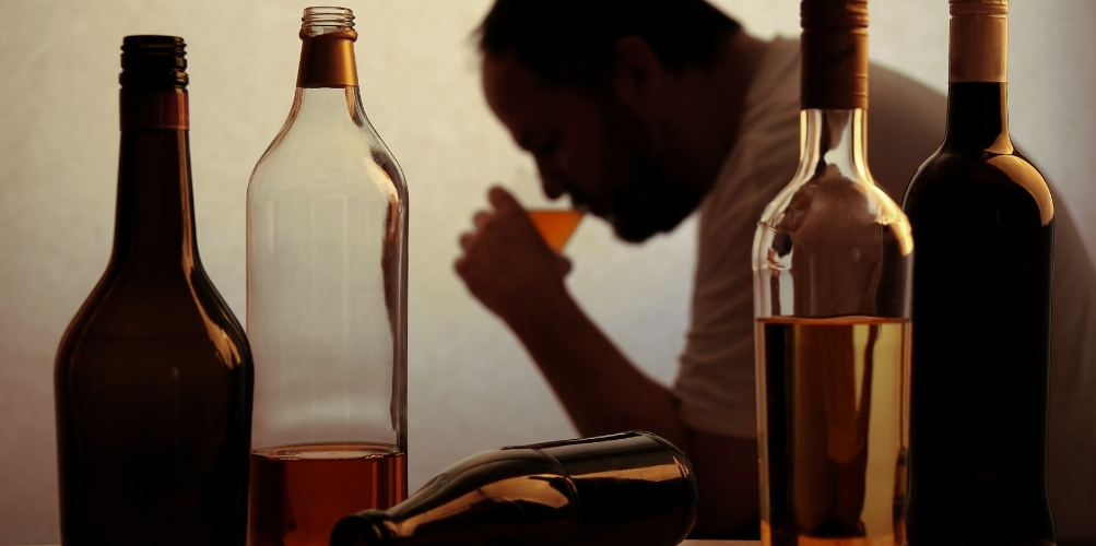 man drinking alcohol in the dark