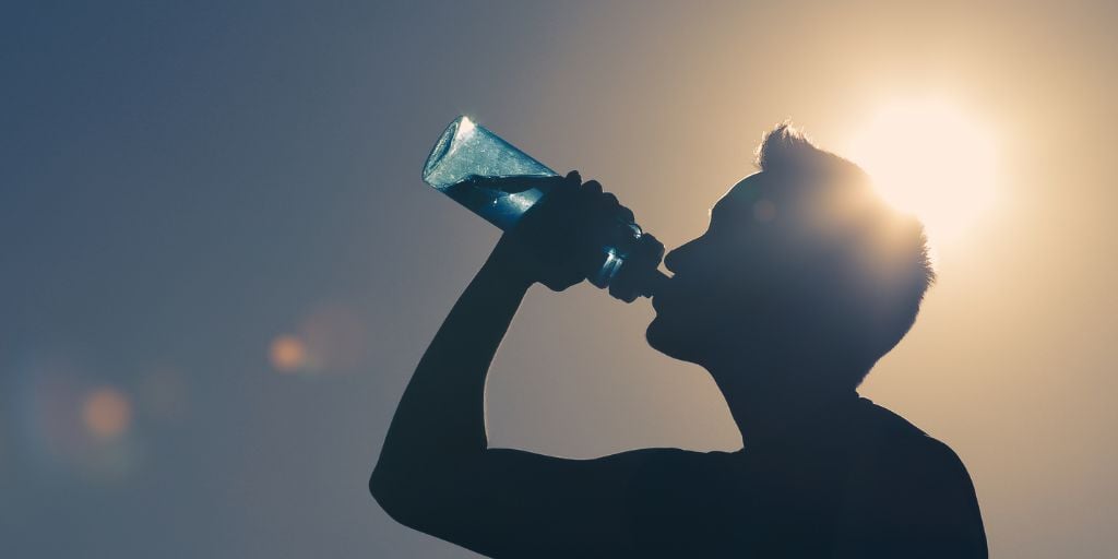 silhouette of a man drinking water