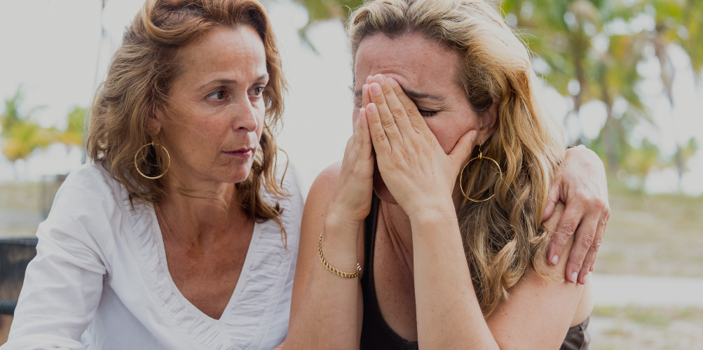 mother comforting adult daughter