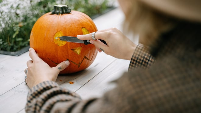 woman carving a pumpkin