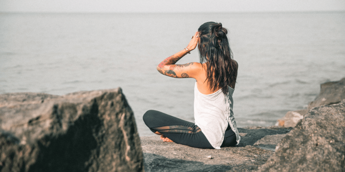 woman meditating on beach